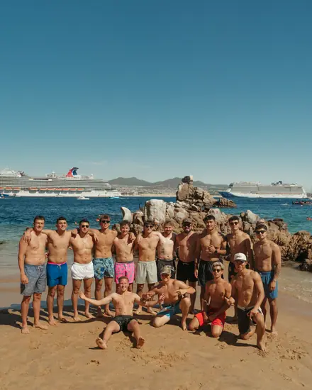 The team on the beach by a cruise ship